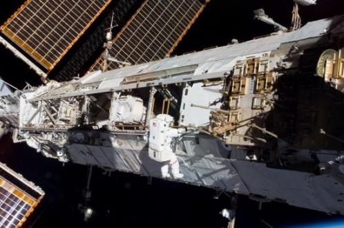 Un astronaute installe un instrument sur la poutre principale... (image NASA)